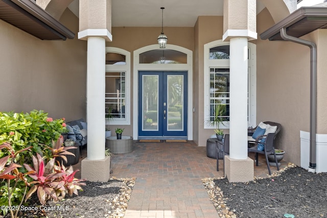 entrance to property featuring french doors and stucco siding