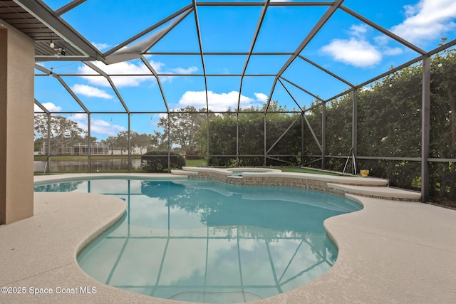 outdoor pool featuring glass enclosure, a patio, and an in ground hot tub