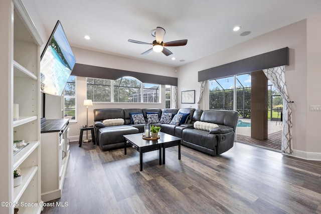 living area featuring baseboards, dark wood finished floors, a ceiling fan, and recessed lighting