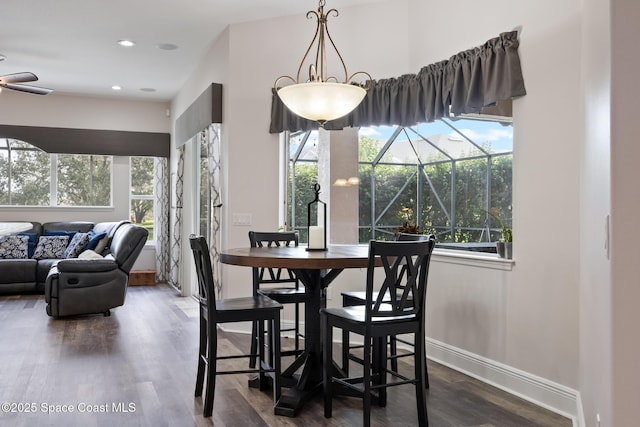 dining space featuring dark wood finished floors, recessed lighting, a sunroom, ceiling fan, and baseboards