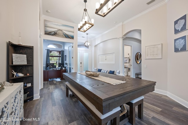 dining room featuring baseboards, visible vents, arched walkways, dark wood finished floors, and crown molding