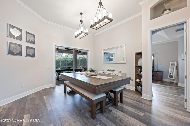 dining room featuring dark wood-style floors, crown molding, and baseboards