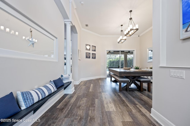 entrance foyer with dark wood-style floors, decorative columns, crown molding, a chandelier, and baseboards