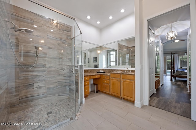 ensuite bathroom with ensuite bath, vanity, a shower stall, a chandelier, and recessed lighting