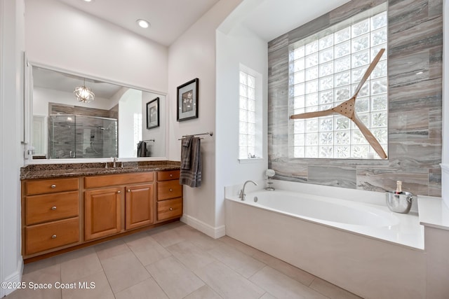 full bath with a garden tub, vanity, baseboards, tile patterned floors, and a stall shower