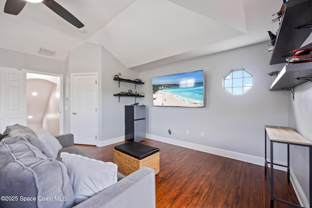 living room featuring dark wood-style floors, arched walkways, visible vents, and baseboards