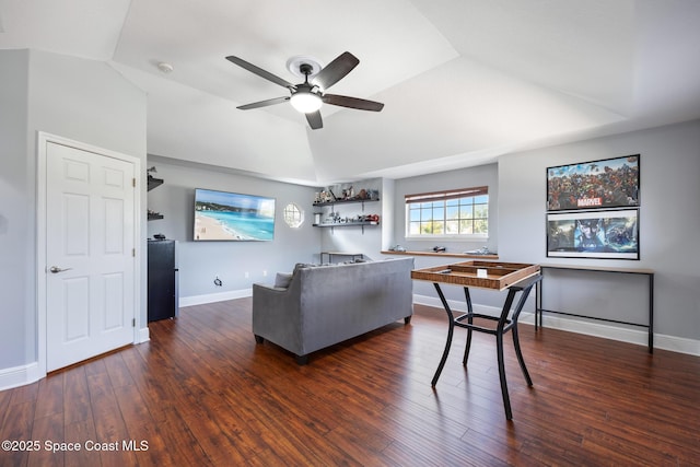 living area with lofted ceiling, dark wood-style flooring, a raised ceiling, and baseboards