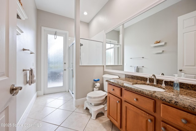 bathroom featuring vanity, a shower stall, toilet, and tile patterned floors