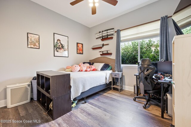 bedroom with a ceiling fan, baseboards, and wood finished floors