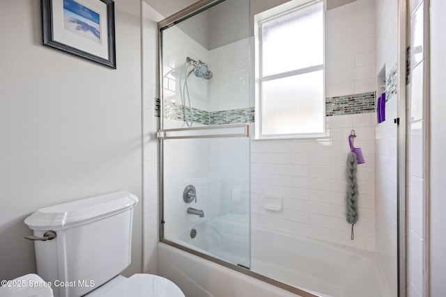 bathroom with toilet and combined bath / shower with glass door