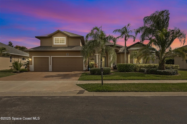 view of front of home featuring concrete driveway, an attached garage, and stucco siding