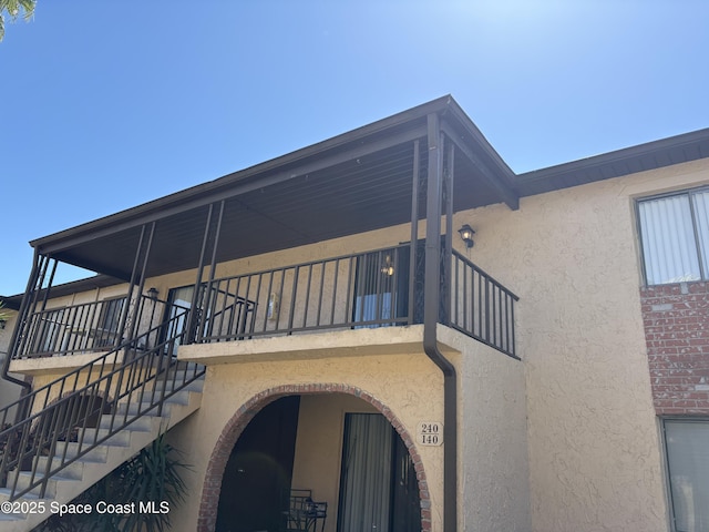 exterior space with stairway and stucco siding