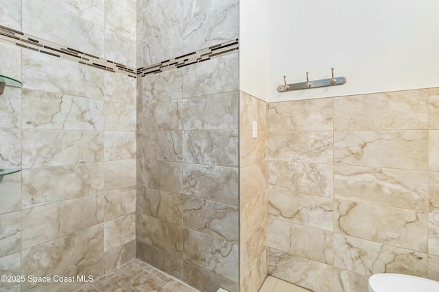 bathroom featuring toilet and a tile shower