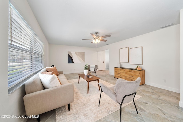 living area featuring a ceiling fan, visible vents, and baseboards