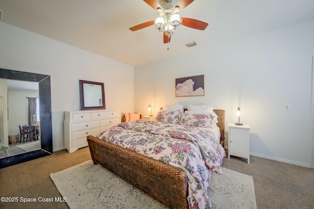 bedroom with light colored carpet, ceiling fan, visible vents, and baseboards