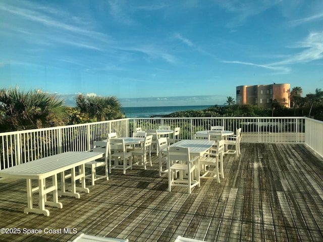 wooden deck featuring a water view and outdoor dining space