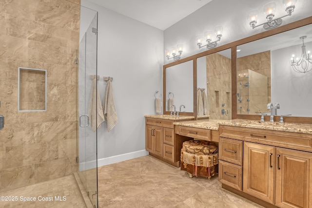 full bath featuring vanity, a shower stall, baseboards, and a chandelier