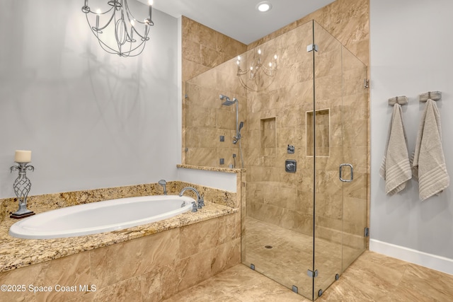 bathroom featuring a bath, baseboards, a stall shower, and a chandelier