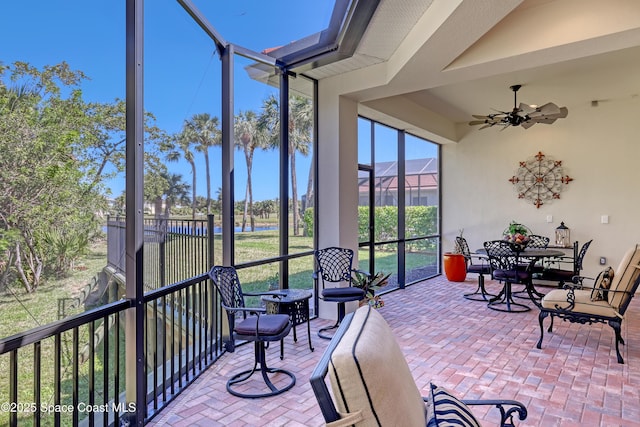 sunroom / solarium featuring a ceiling fan