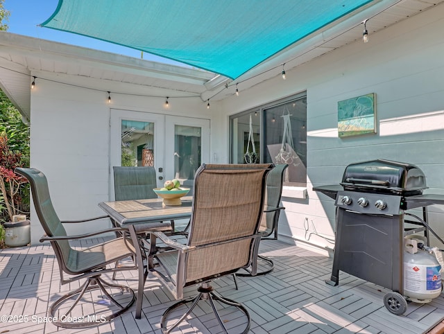 wooden deck with outdoor dining area, a patio area, and area for grilling