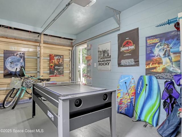 recreation room with a garage and concrete floors