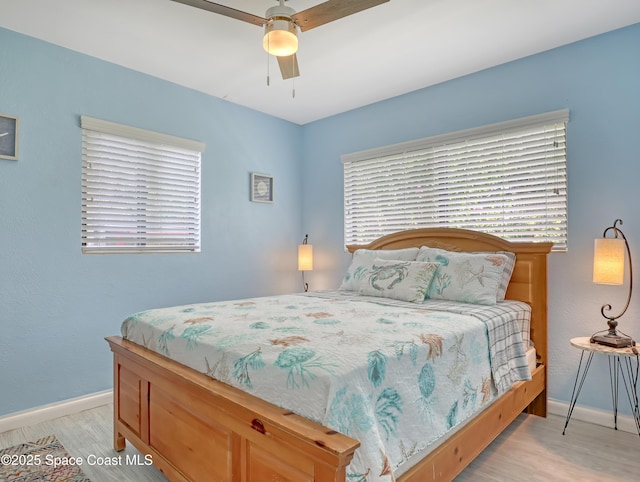 bedroom with a ceiling fan, light wood-style flooring, and baseboards