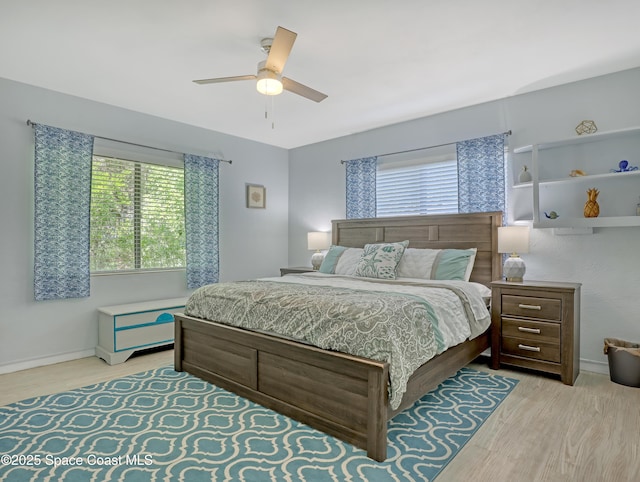 bedroom featuring light wood-type flooring, a ceiling fan, and baseboards