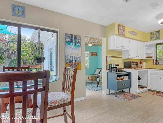 kitchen with white cabinetry, a ceiling fan, backsplash, open shelves, and light wood finished floors