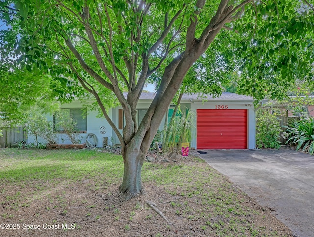 view of front of property with a garage, a front yard, stucco siding, and aphalt driveway