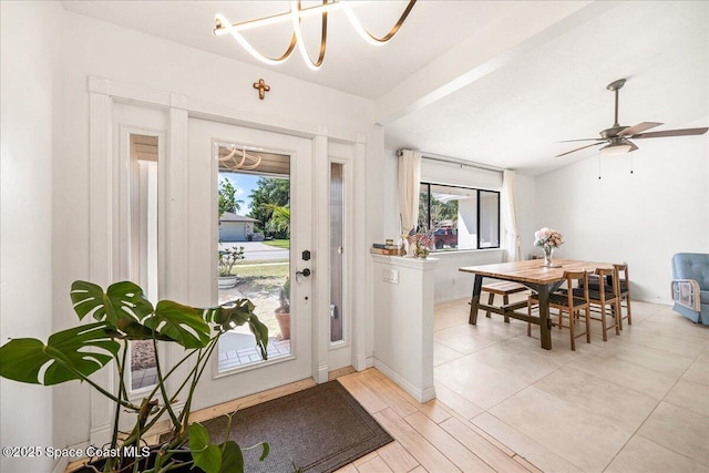 foyer entrance with light wood-type flooring, lofted ceiling, and ceiling fan with notable chandelier