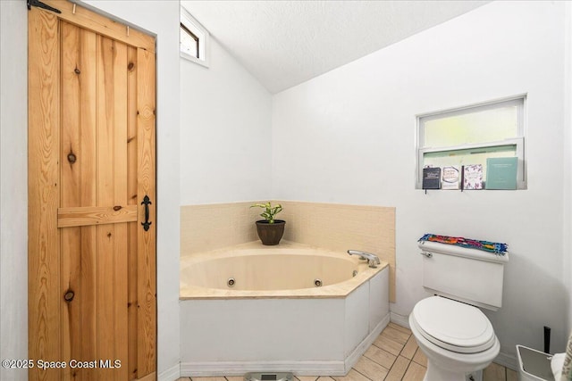 bathroom featuring baseboards, toilet, lofted ceiling, a jetted tub, and tile patterned flooring