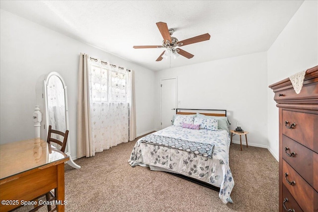 carpeted bedroom with ceiling fan and baseboards