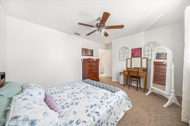 carpeted bedroom with visible vents and a ceiling fan