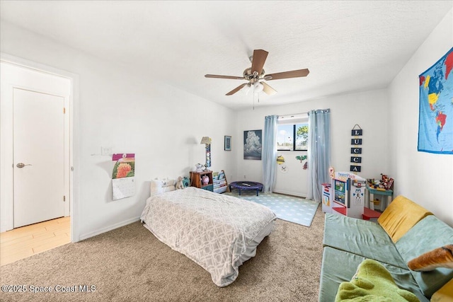 carpeted bedroom featuring ceiling fan and a textured ceiling