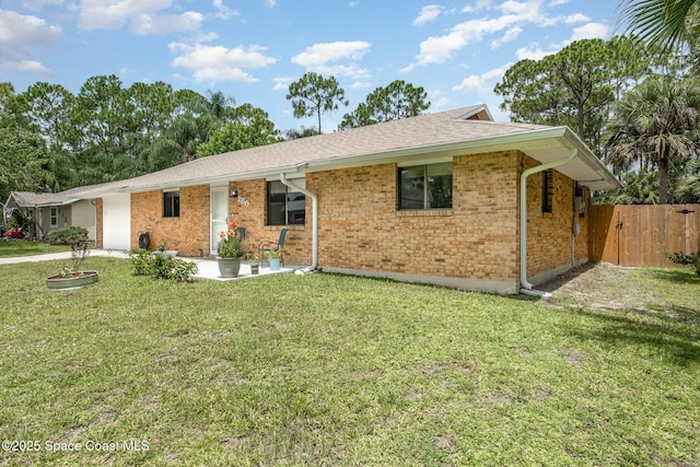 single story home featuring a garage, brick siding, fence, roof with shingles, and a front yard