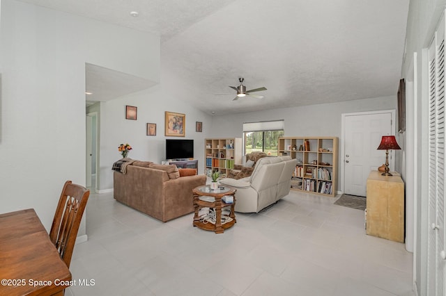 living room featuring baseboards, vaulted ceiling, and a ceiling fan