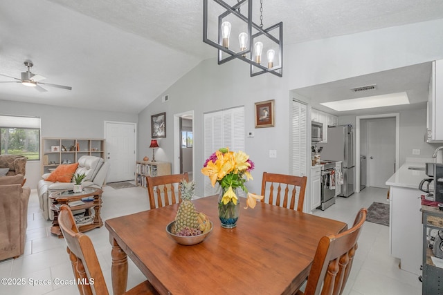 dining area with ceiling fan with notable chandelier, visible vents, vaulted ceiling, and light tile patterned flooring