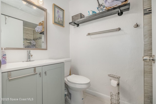 bathroom with a tile shower, vanity, toilet, and tile patterned floors