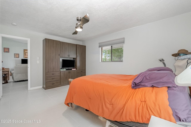 bedroom with a textured ceiling, baseboards, a ceiling fan, and light tile patterned flooring