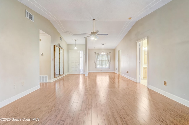 empty room with vaulted ceiling, light wood-style flooring, and visible vents