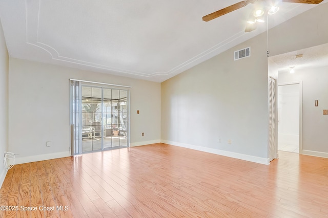 spare room with lofted ceiling, visible vents, ceiling fan, and light wood finished floors