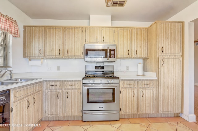 kitchen featuring light tile patterned floors, visible vents, light brown cabinets, and appliances with stainless steel finishes