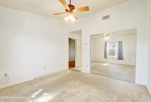 unfurnished room with carpet floors, ceiling fan, visible vents, and baseboards