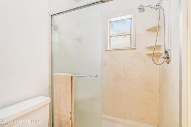 bathroom featuring a shower stall and toilet