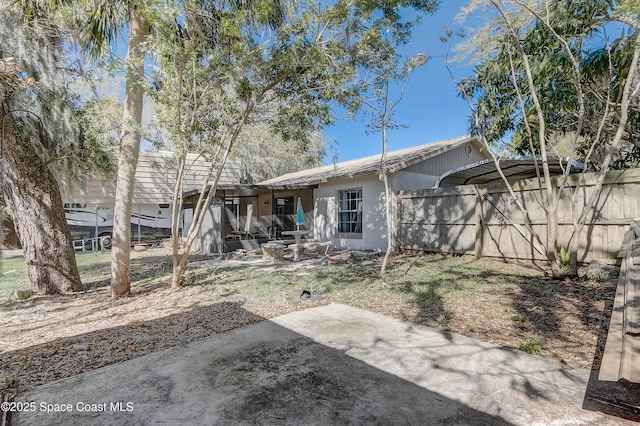 back of property featuring stucco siding, fence, and a patio