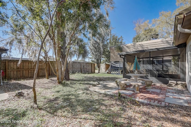 view of yard with a sunroom and fence