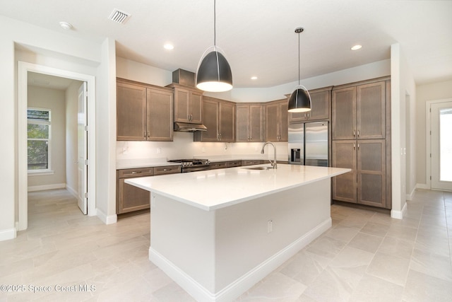 kitchen featuring a healthy amount of sunlight, stainless steel appliances, light countertops, and a sink