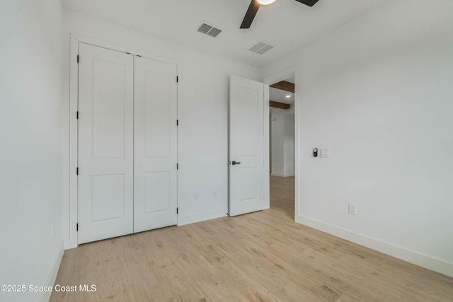 unfurnished bedroom featuring a closet, visible vents, light wood-style flooring, and baseboards