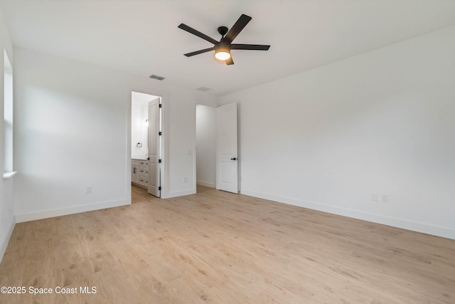 unfurnished bedroom featuring visible vents, ceiling fan, ensuite bath, wood finished floors, and baseboards