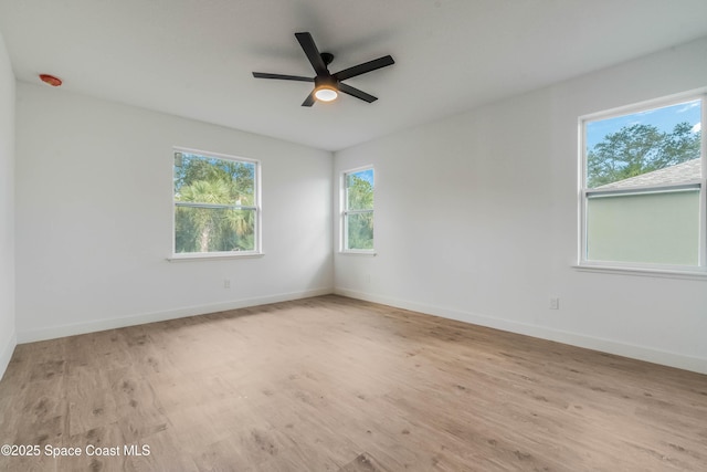 empty room featuring ceiling fan, baseboards, and wood finished floors